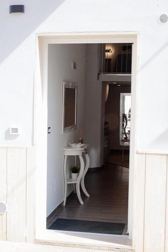 a white room with a table and a mirror at Donna Anna in Polignano a Mare