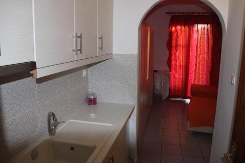 a kitchen with a sink and a red curtain at Vaya Zorba Studios in Skiathos Town