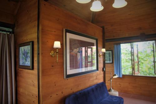a living room with a blue couch and two windows at Zen Cafe Countryside Retreat in Bon Da Xi