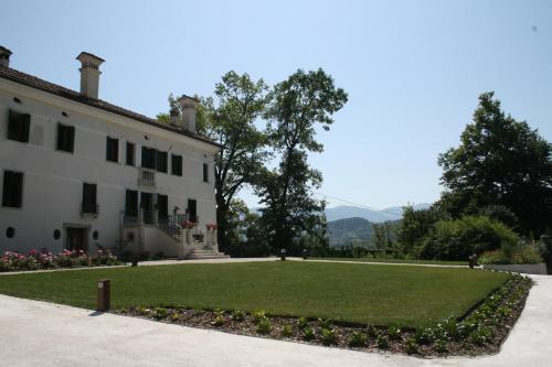 a large white building with a lawn in front of it at Villa San Liberale - Suites & Wellness - Villa Veneta in Feltre