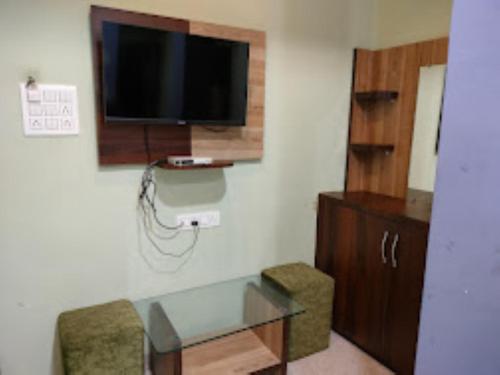 Zimmer mit einem Schreibtisch und einem TV an der Wand in der Unterkunft Hotel Shivalay Palace,Maheshwar in Maheshwar