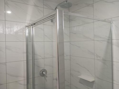 a shower with a glass door in a bathroom at Big Valley Lakeside Paradise Motor Inn in Shepparton