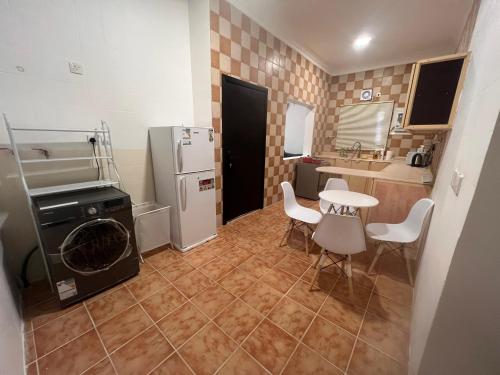 a small kitchen with a table and a refrigerator at Ban Luxury Apartments in Al Khobar