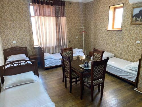 Habitación con 2 camas, mesa y sillas en ANIS HOTEL en Samarcanda