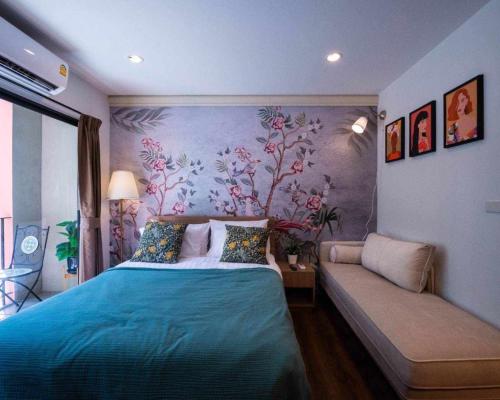 a bedroom with a bed and a couch at La Habana Hua Hin by Wilmot-200 m from the beach in Khao Tao