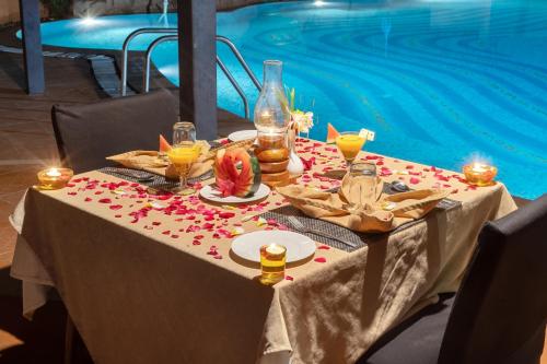 una mesa para una fiesta frente a la piscina en Vijayshree Resort, Hampi, en Hampi