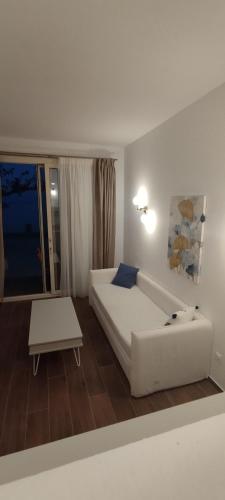 a living room with a white couch and a table at Nostos in Patitiri