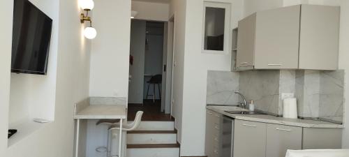 a small kitchen with white cabinets and a staircase at Nostos in Patitiri