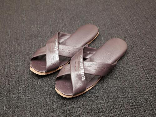 a pair of brown sandals sitting on a table at Hotel Route-Inn Toyama Ekimae in Toyama