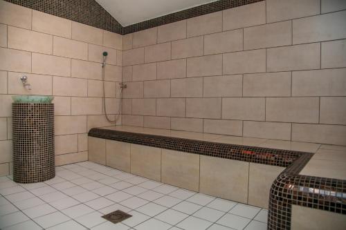 a tiled bathroom with a shower and a tub at Zirgu sēta "Klajumi" - Horse ranch "Klajumi" in Kaplava