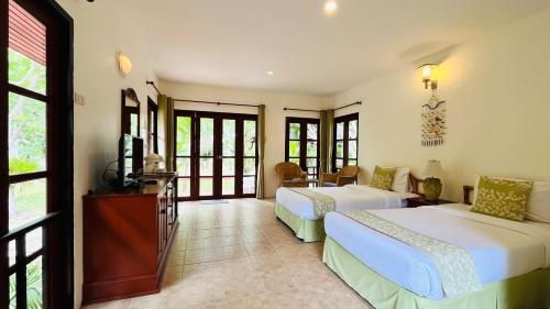 a bedroom with two beds and a television in it at Suan Bankrut Beach Resort in Ban Krut