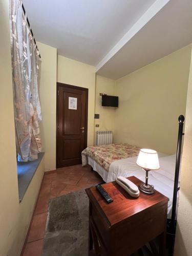 a bedroom with a bed and a table with a telephone at Corte Dell' Oca in Subbiano