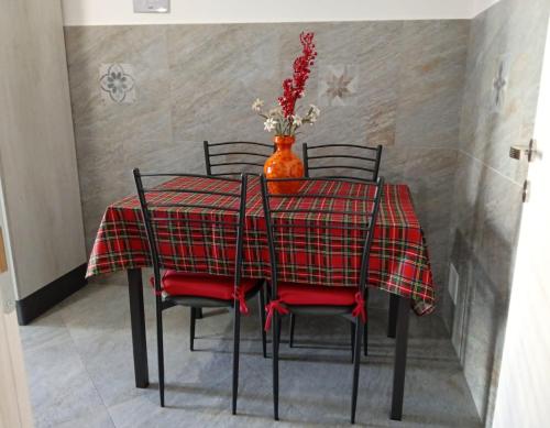 a dining room table with red chairs and a vase with flowers at casaLucina in Rome