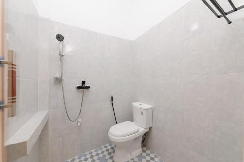 ein Bad mit einem WC und einer Dusche in der Unterkunft RedDoorz Plus Syariah near Mall Boemi Kedaton Lampung in Kedaton