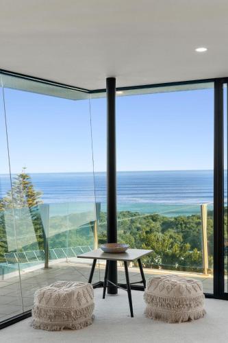a room with a table and a view of the ocean at Orton Oceanview Luxury Retreat in Ocean Grove