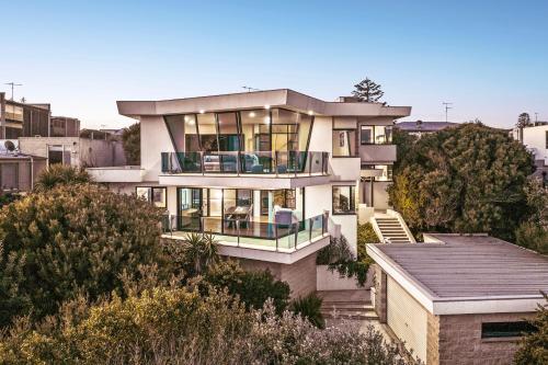 a large house on a hill with trees at Orton Oceanview Luxury Retreat in Ocean Grove