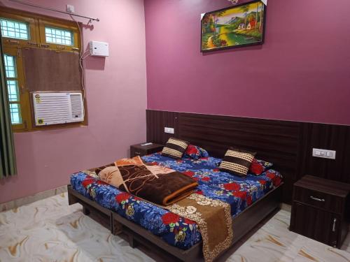 um quarto com uma cama e uma parede roxa em Ratan Homestay em Shivpuri