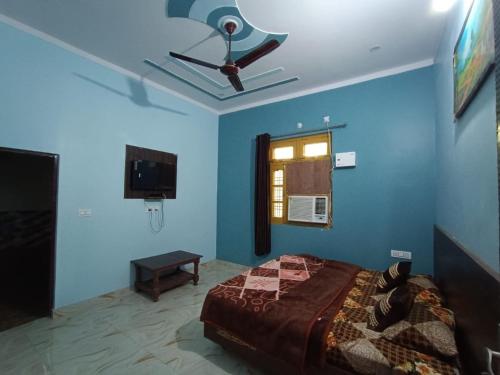 Schlafzimmer mit Deckenventilator und blauen Wänden in der Unterkunft Ratan Homestay in Shivpuri