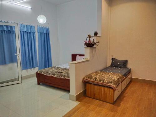 een slaapkamer met een bed en een bank erin bij Gia Khôi Homestay in Hue