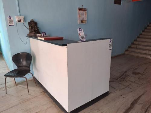 a white counter with a chair in a room at Wonderhills lodge in Hinjewadi