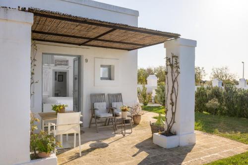 a patio with a table and chairs under a pergola at Masseria Le Torri in Polignano a Mare