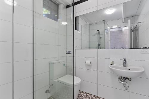 Buderim Fiesta Motel في Tanawha: حمام ابيض مع مرحاض ومغسلة