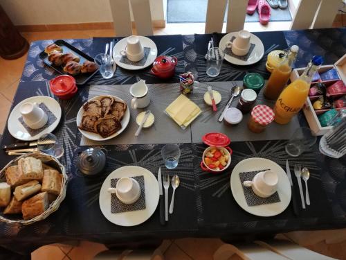 einen Tisch mit Teller mit Speisen und Brot in der Unterkunft Celine'Home in Saint-Germain-sur-Morin