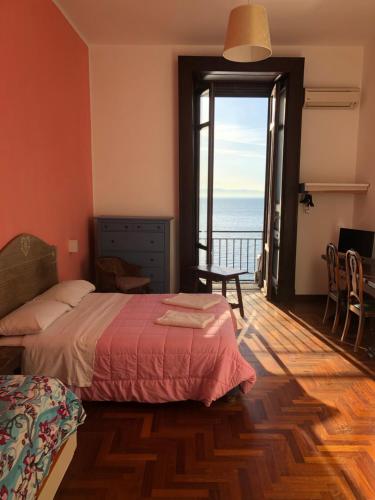 B&B Vista Mare في نابولي: غرفة نوم مع سرير وإطلالة على المحيط