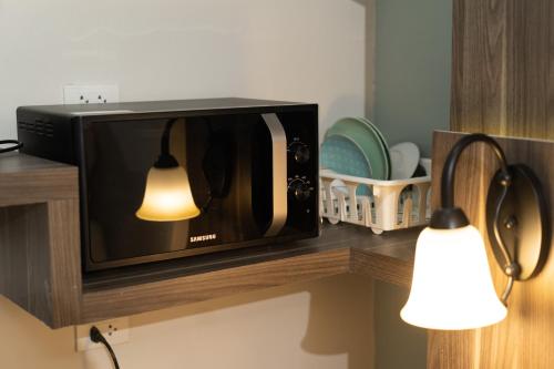 a microwave sitting on a counter with a light on it at We Resident Hotel in Hat Yai
