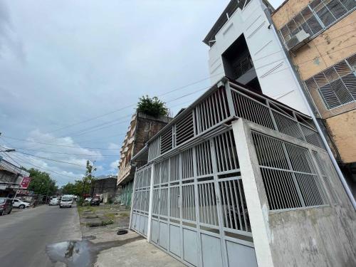 a building with a gate on the side of a street at RedDoorz at Ramelau near AP Pettarani in Makassar