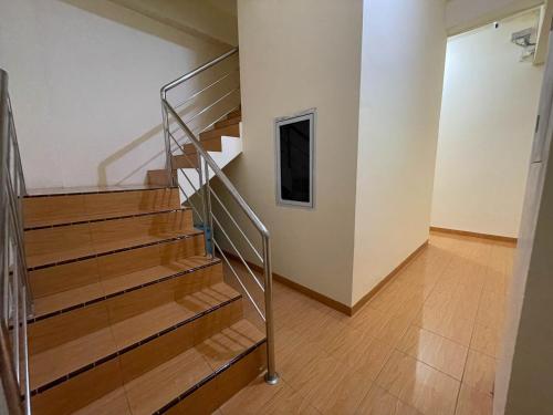 a staircase with a metal railing in a room at RedDoorz at Ramelau near AP Pettarani in Makassar