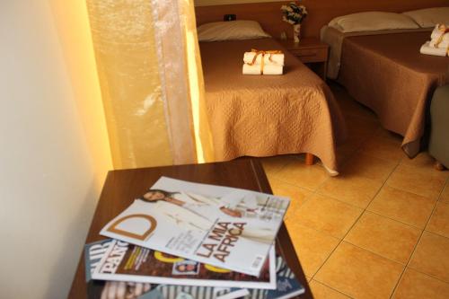a room with two beds and a table with books at B&B La Vigna in Lamezia Terme