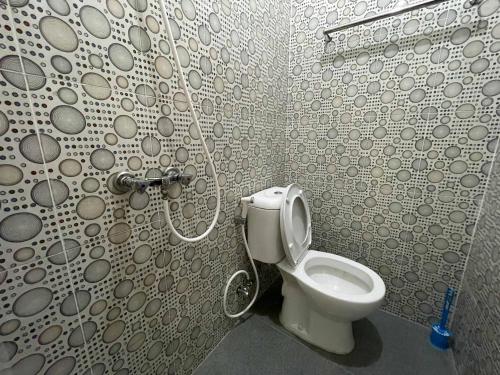a bathroom with a toilet in a shower at RedDoorz at Ramelau near AP Pettarani in Makassar