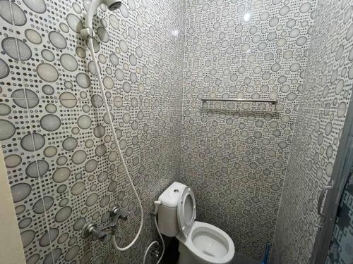 a bathroom with a shower with a toilet in it at RedDoorz at Ramelau near AP Pettarani in Makassar