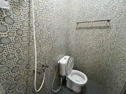 a small bathroom with a toilet in a shower at RedDoorz at Ramelau near AP Pettarani in Makassar