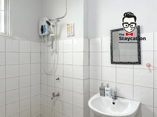 un baño con lavabo y un cartel en la pared en Staycation Homestay 33 Floridale Condominium near viva city, en Kuching