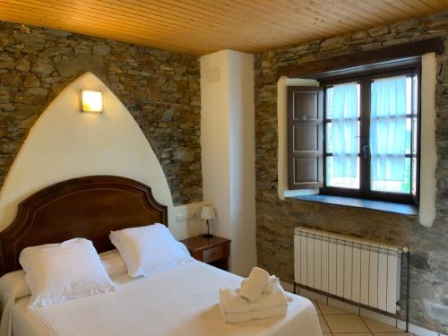 Un dormitorio con una cama grande y una ventana en Hotel y Apartamentos Penarronda Playa, en Castropol