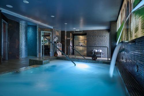 a swimming pool in a hotel room with a bathtub at Gran Hotel Luna de Granada in Granada