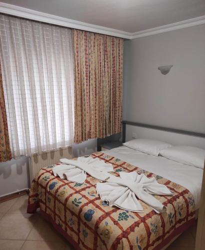 a hotel room with a bed with towels on it at OTEL DEFNE in Polatlı