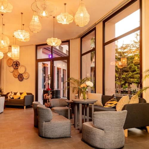 a lobby with a couch and chairs and windows at Novotel Marrakech Hivernage in Marrakech