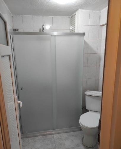 a white bathroom with a toilet and a shower at OTEL DEFNE in Polatlı