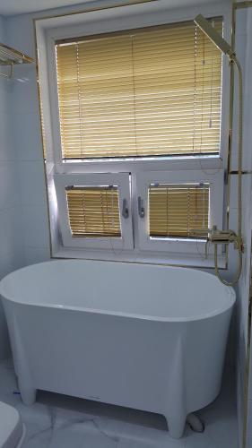 a white bath tub in a bathroom with a window at HANI Haus in Jeju