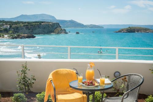 a table and chairs on a balcony with a view of the ocean at Panorama+ in Almirida