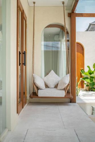 a porch with a swing with pillows on it at Alegria de la Vida in Canggu