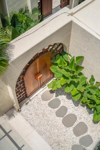 a dog house with a wooden door and a plant at Alegria de la Vida in Canggu