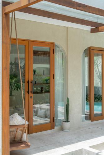 a porch with glass doors and a cactus at Alegria de la Vida in Canggu
