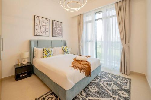 um quarto com uma cama grande e uma janela grande em Lux Golf Views 3 BR in Emirates Hills em Dubai