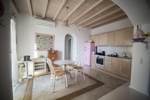 una cucina con tavolo e sedie in una stanza di White Rock Suites & Villas a Houlakia