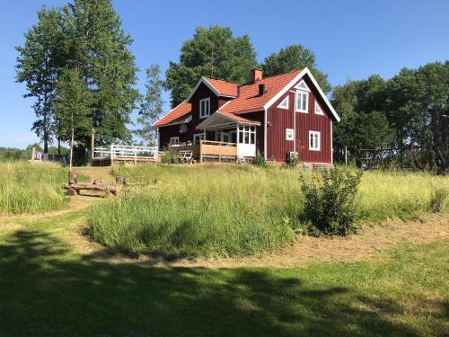 a red house in the middle of a field at Flybo Sjöaborg, Smaland, South Sweden in Åseda