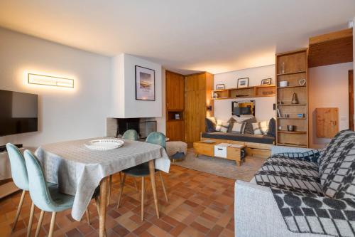 un salon avec une table, des chaises et un canapé dans l'établissement Flat - Le Whivern A stone's throw from the village centre, à Megève